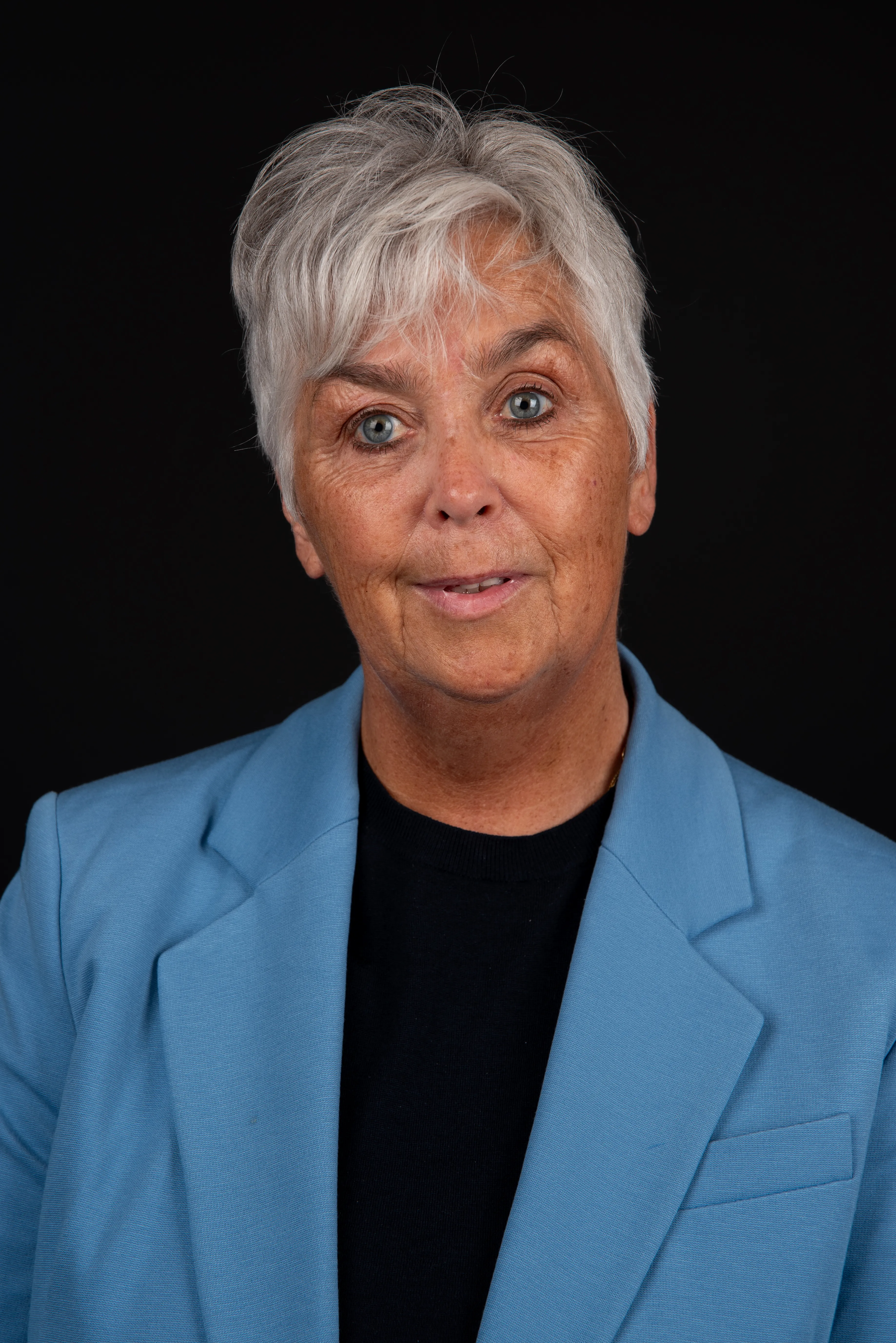 Arlette Vonk, blue blazer, black backdrop, looking directly at the camera