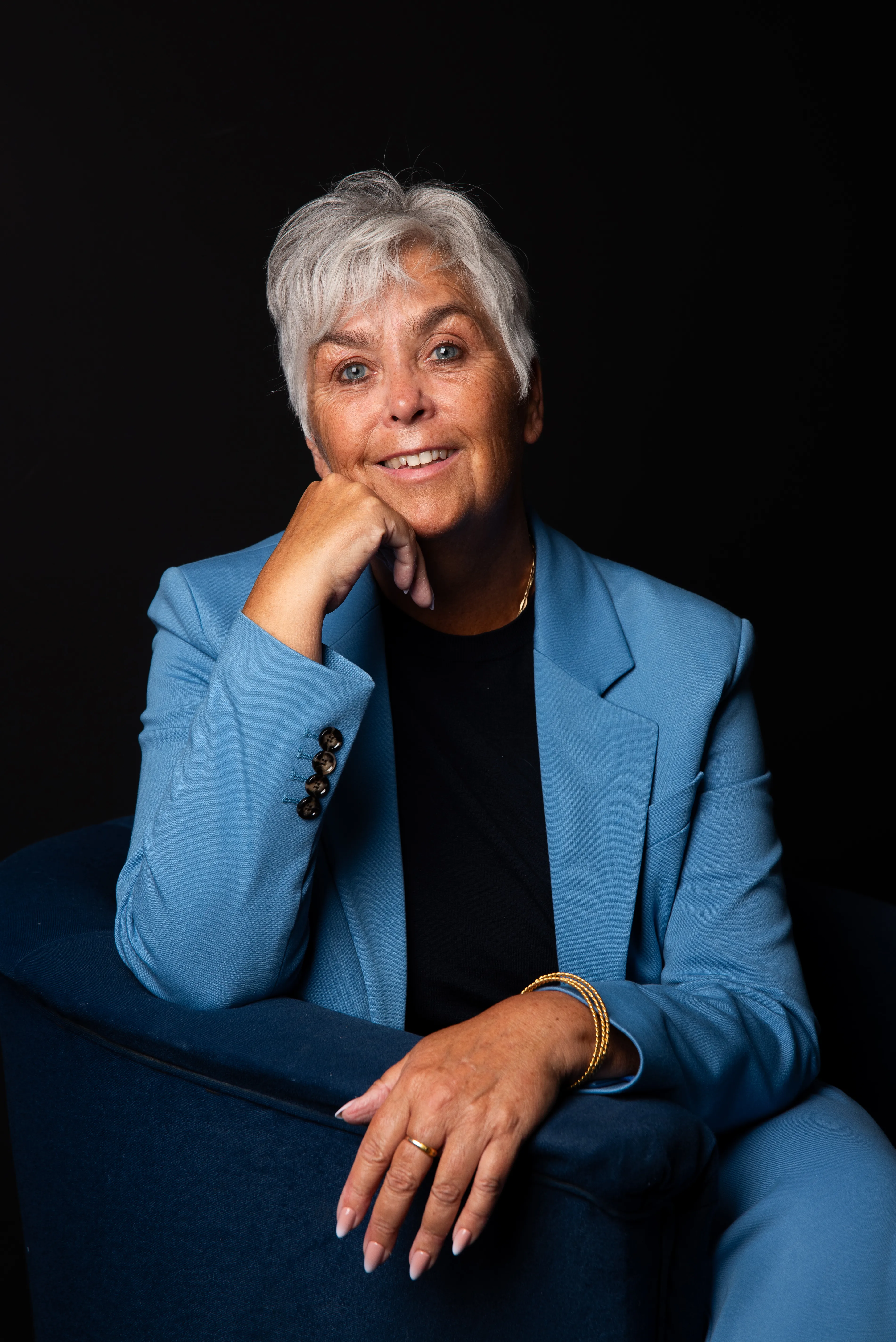 Arlette Vonk, petrol blue blazer, black backdrop