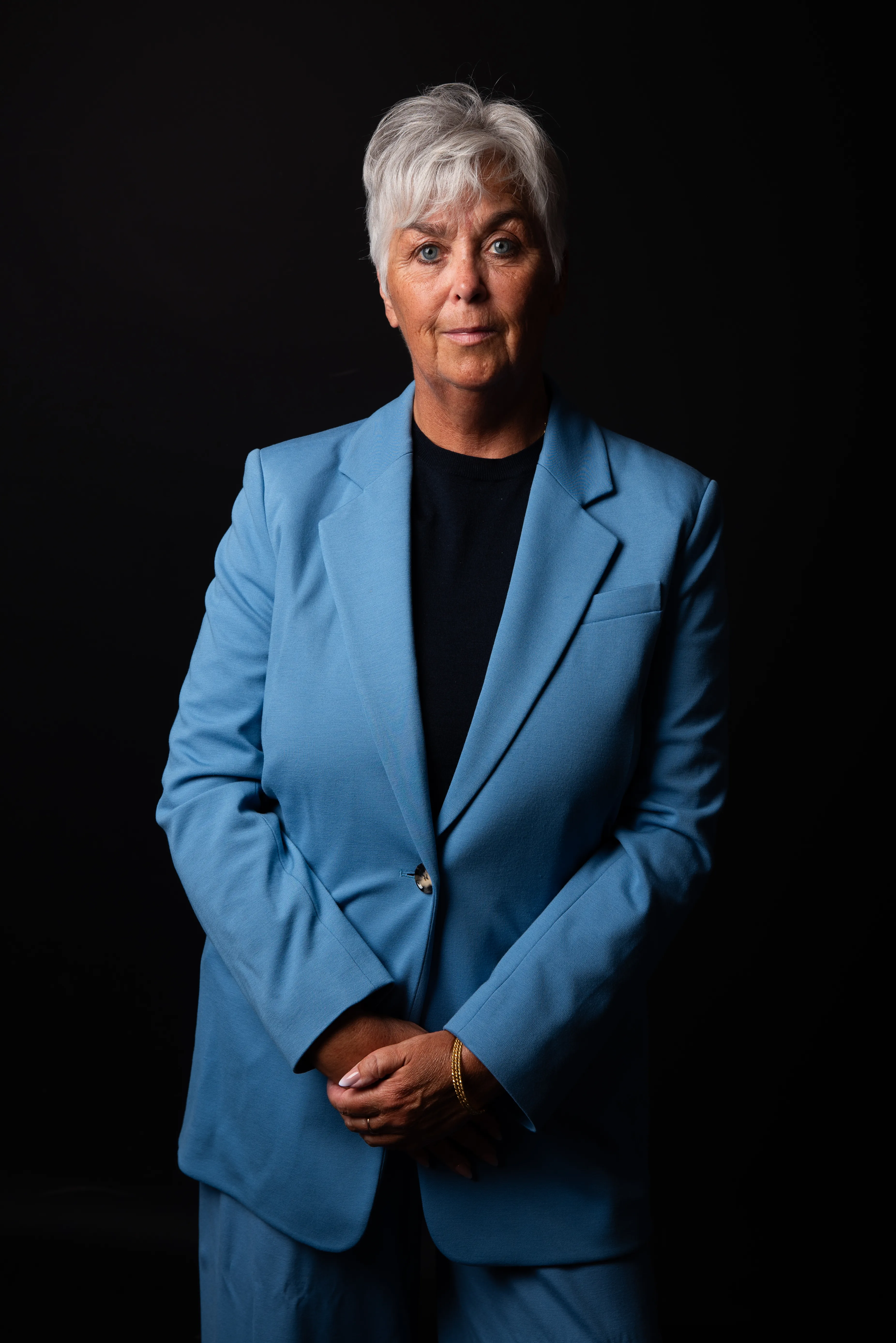 Arlette Vonk standing, hands clasped, looking directly at the camera