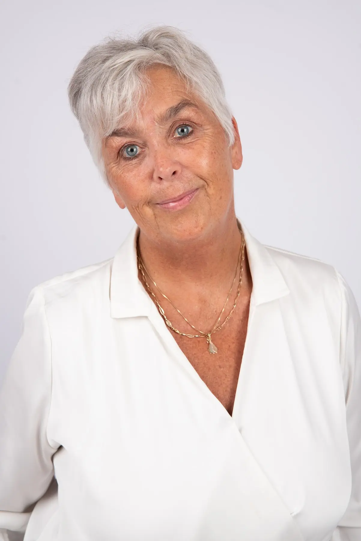 Arlette Vonk in a white blouse, warm smile, light backdrop